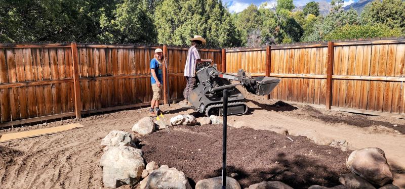 Mini skid steer and crew doing landscape work